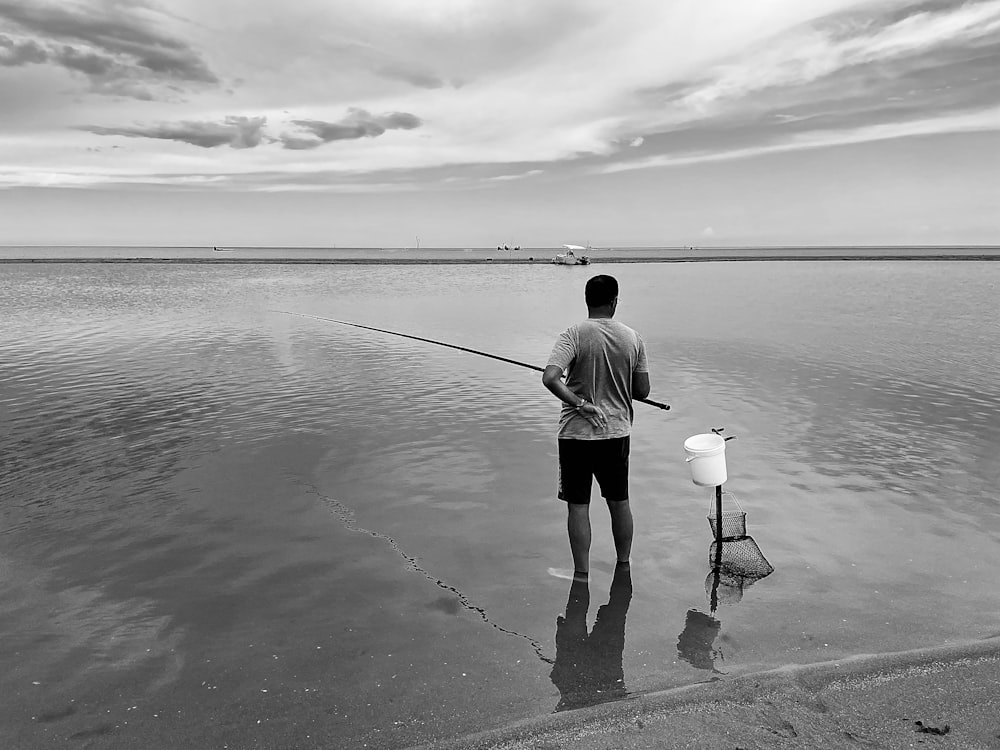 Un uomo che pesca su una spiaggia