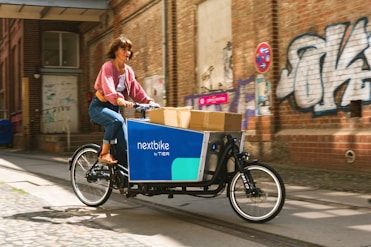 a person riding a bicycle with a cart full of boxes