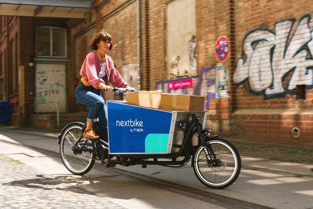 a person riding a bicycle with a cart full of boxes