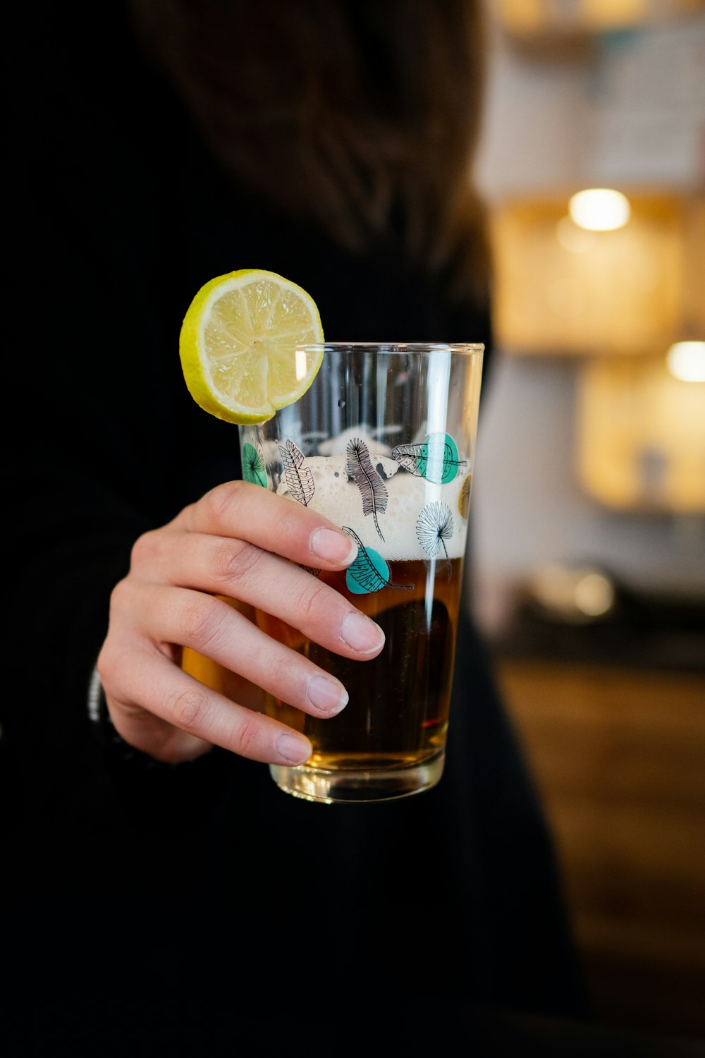 a person holding a glass of beer