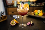 A vibrant cocktail garnished with fresh fruit on a bar.