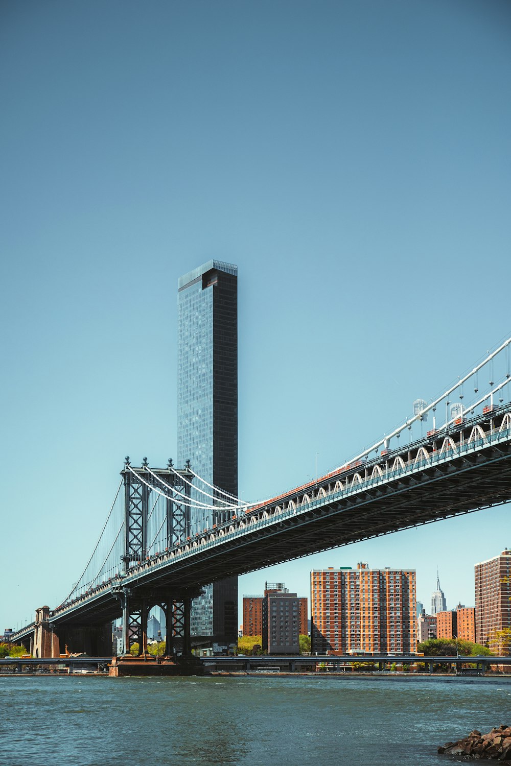 a bridge over water with a tall building in the background