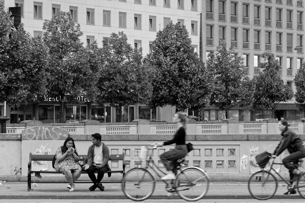 people riding bikes on a sidewalk