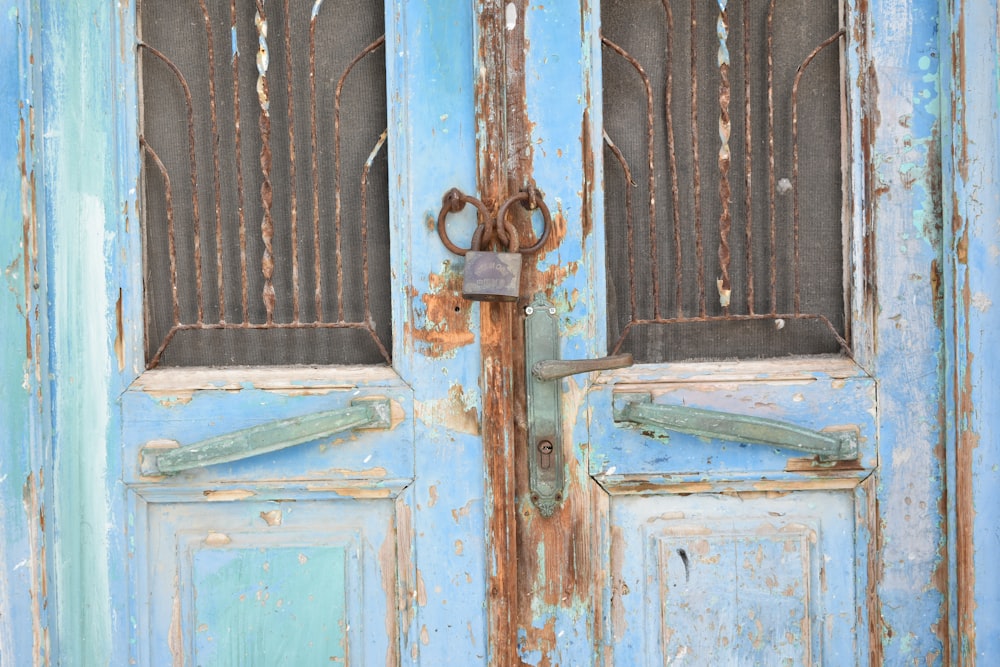 a blue door with rusted locks