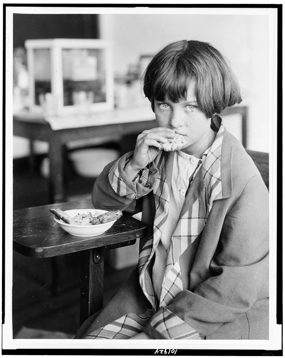 Victime de la sécheresse, une jeune fille de l’école Duncan Consolidated dans le Mississippi, mangeant des biscuits aux raisins de Corinthe, venus de Grèce par l’intermédiaire de la Croix-Rouge junior de ce pays.