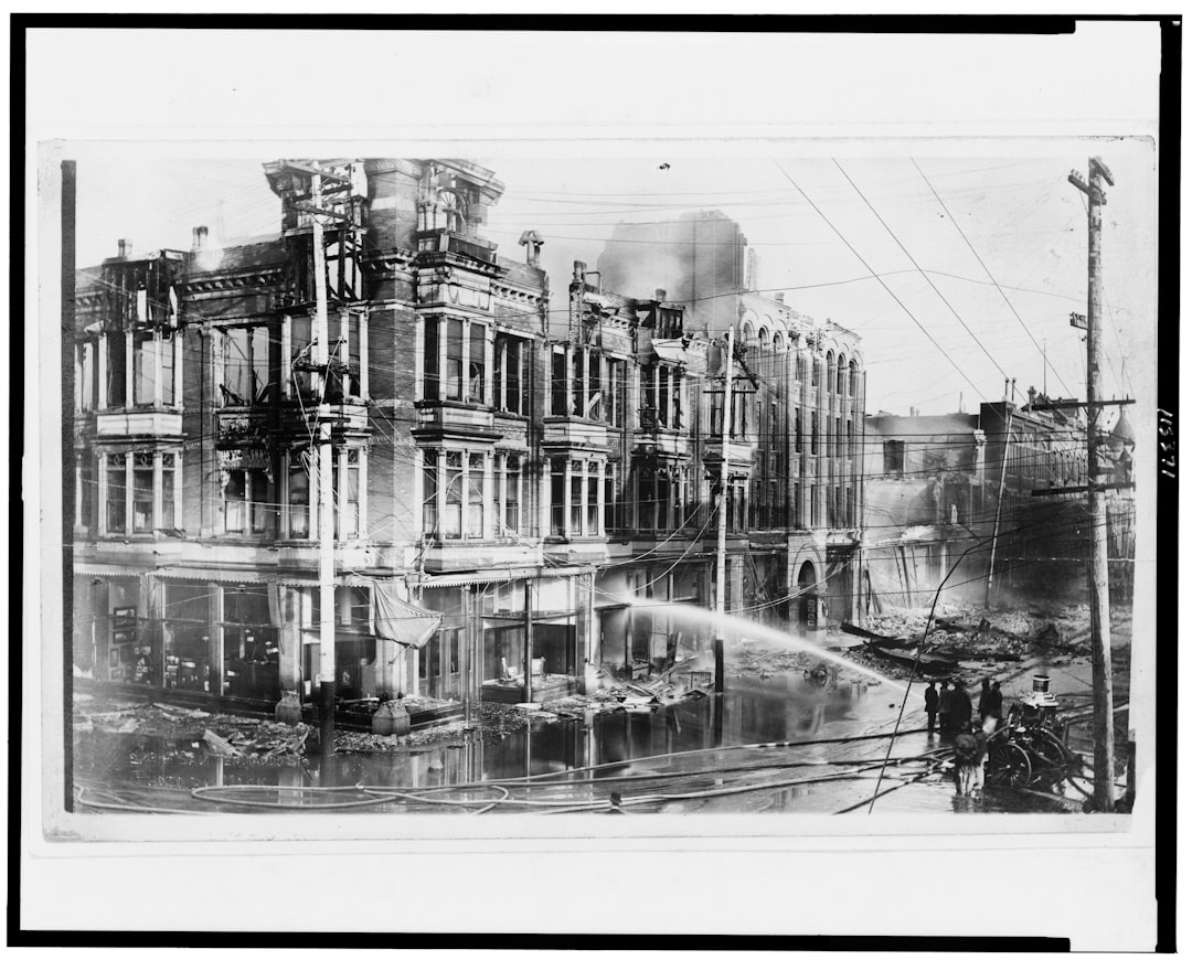 Block of burned buildings in San Francisco after the 1906 earthquake with fire truck spraying water on them., Block of b