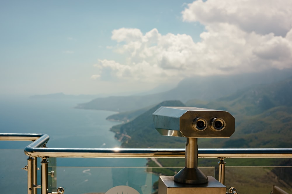 a binoculars on a railing overlooking a body of water