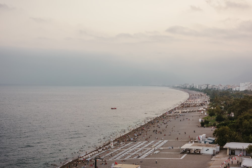 a beach with a body of water and buildings on the side