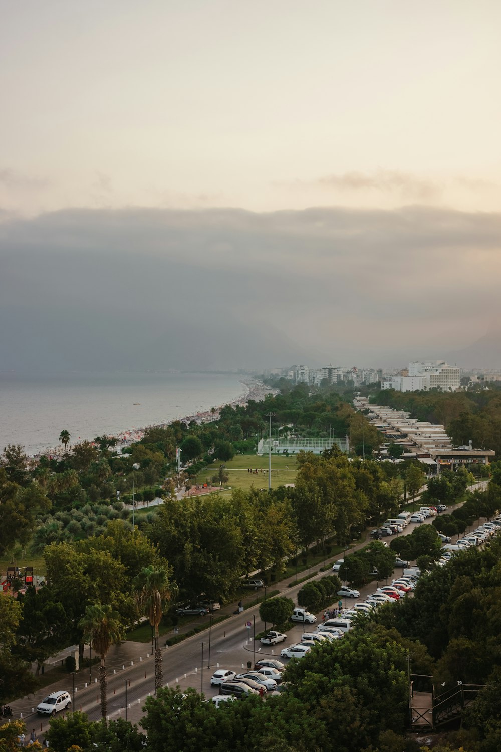 a parking lot with cars and a body of water in the background