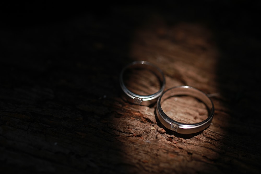 a pair of wedding rings on a wood surface