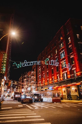 Sign of 'Welcome to Little Italy" lit up at night