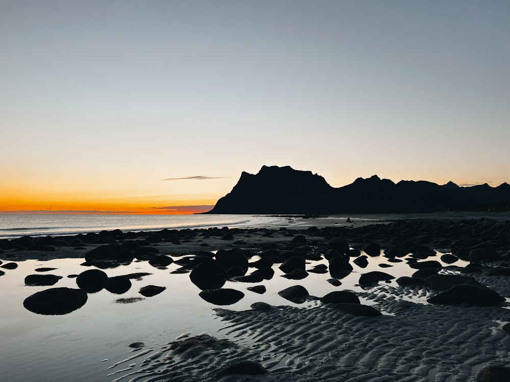 a rocky beach with a sunset