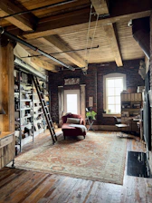a room with a ladder and bookshelves