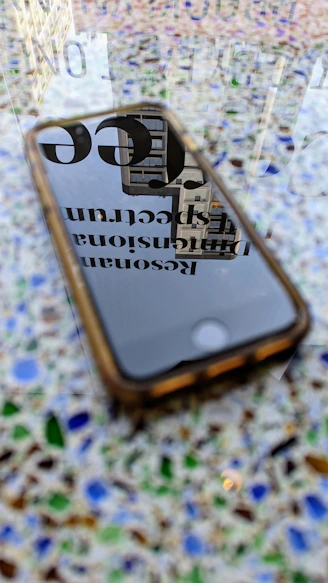 A sleek smartphone resting on a wooden table with a vibrant cityscape reflected on its screen.