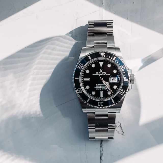 A Rolex Submariner Date with a black dial and black bezel lying on a white surface