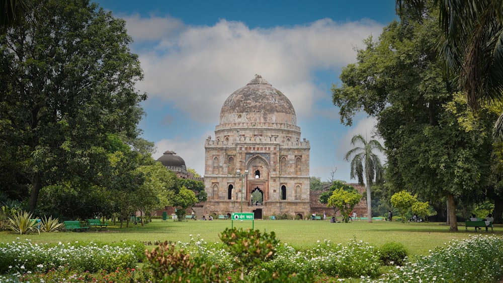 a large building with a dome and trees in front of it