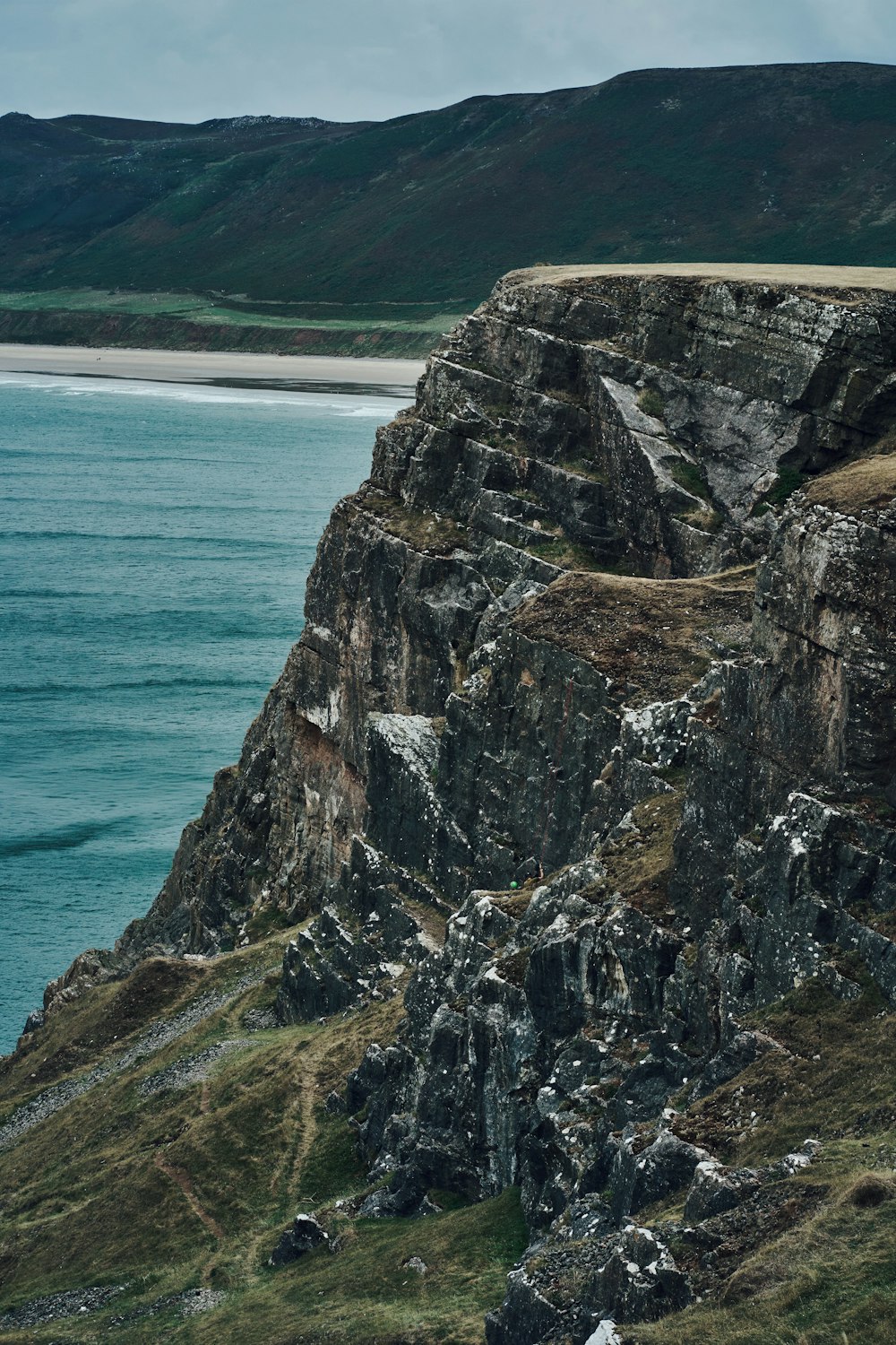 a cliff side with a body of water below