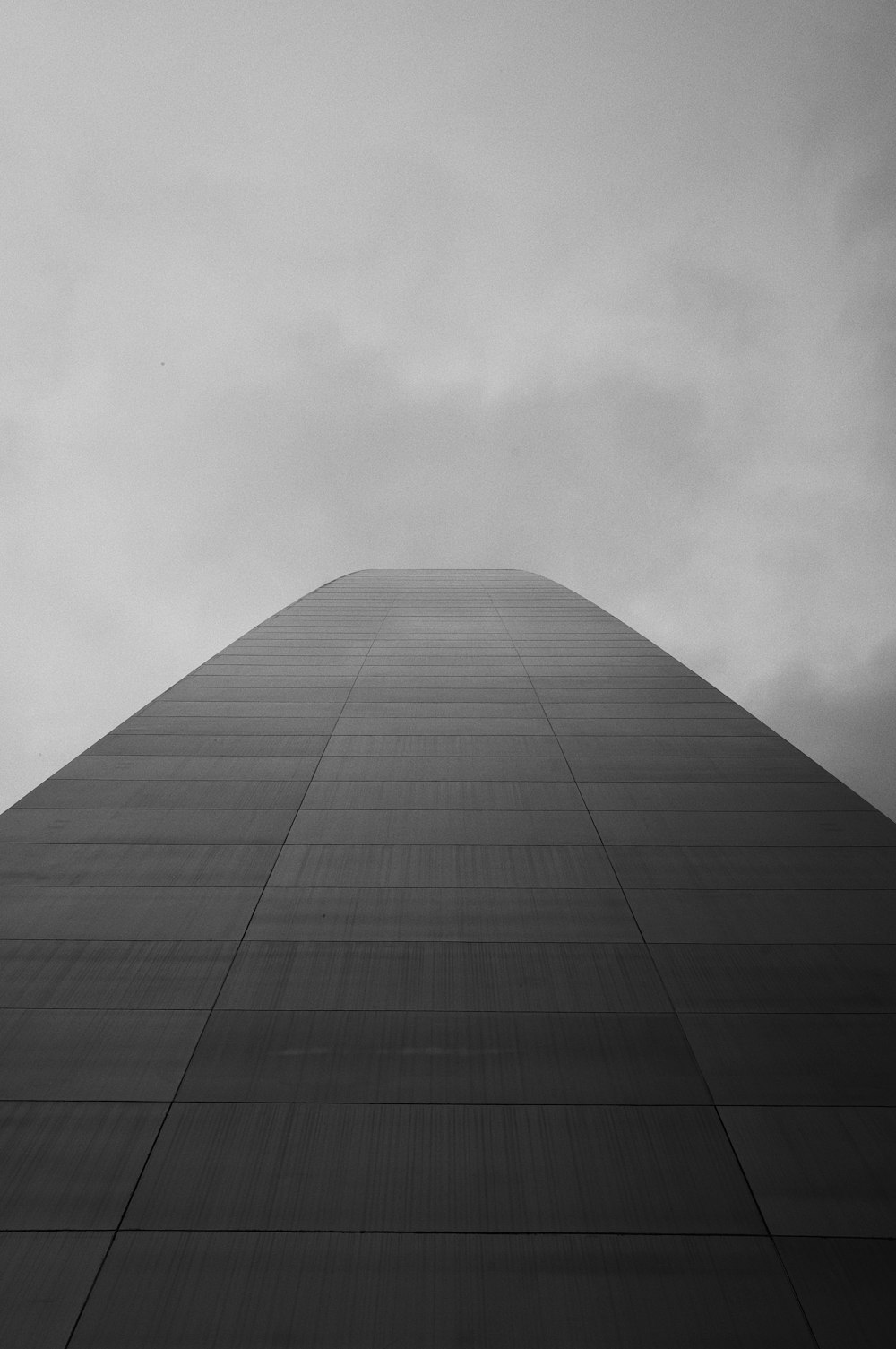 Un edificio alto con un cielo nuvoloso