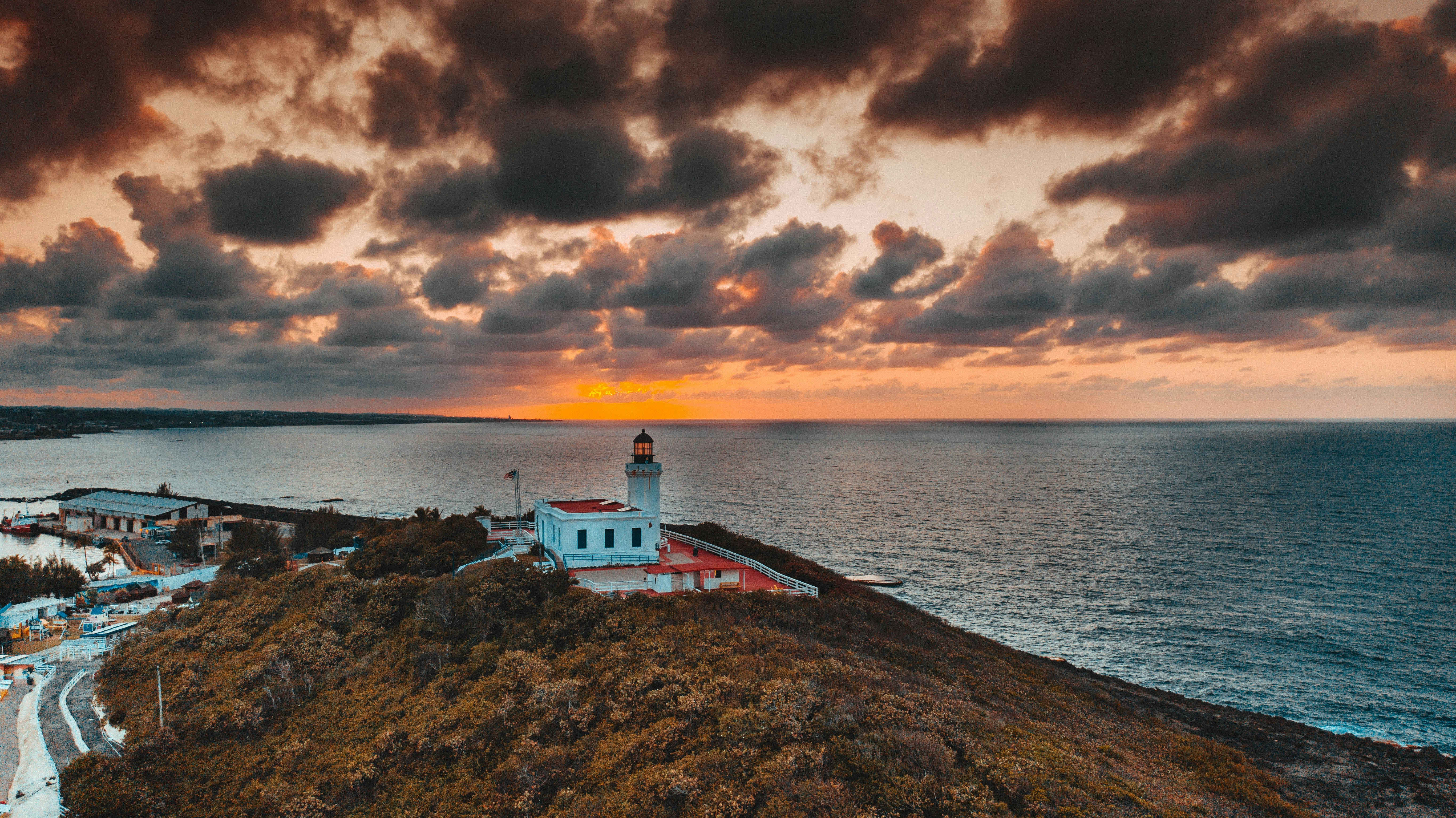 a lighthouse on a hill by the water