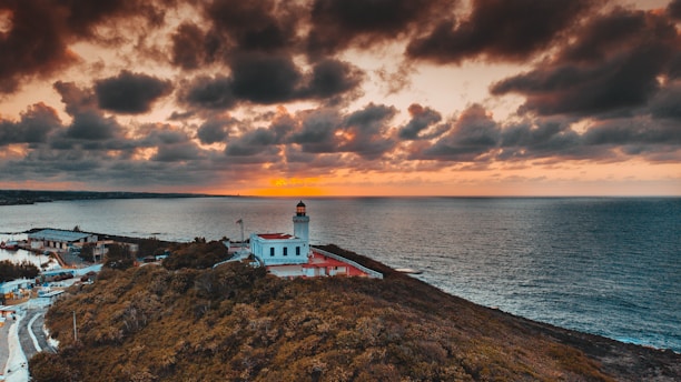 a lighthouse on a hill by the water