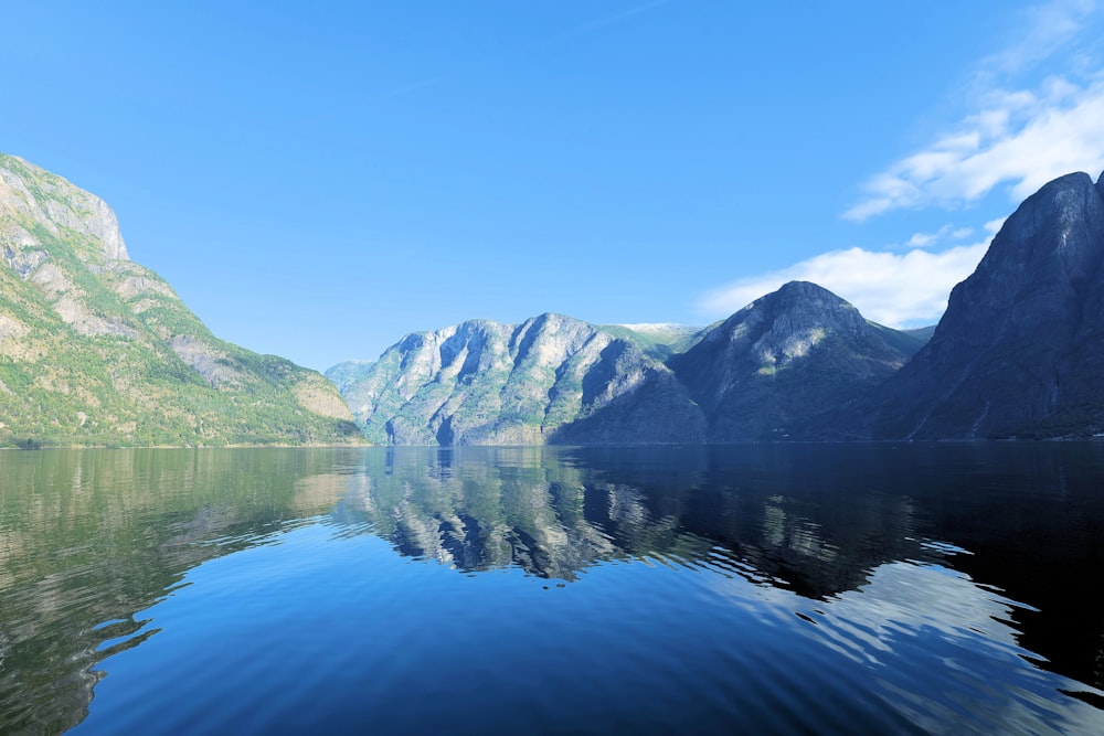 a body of water with mountains in the background