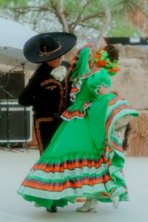 a woman in a colorful dress and hat with a man in a black hat and a black coat