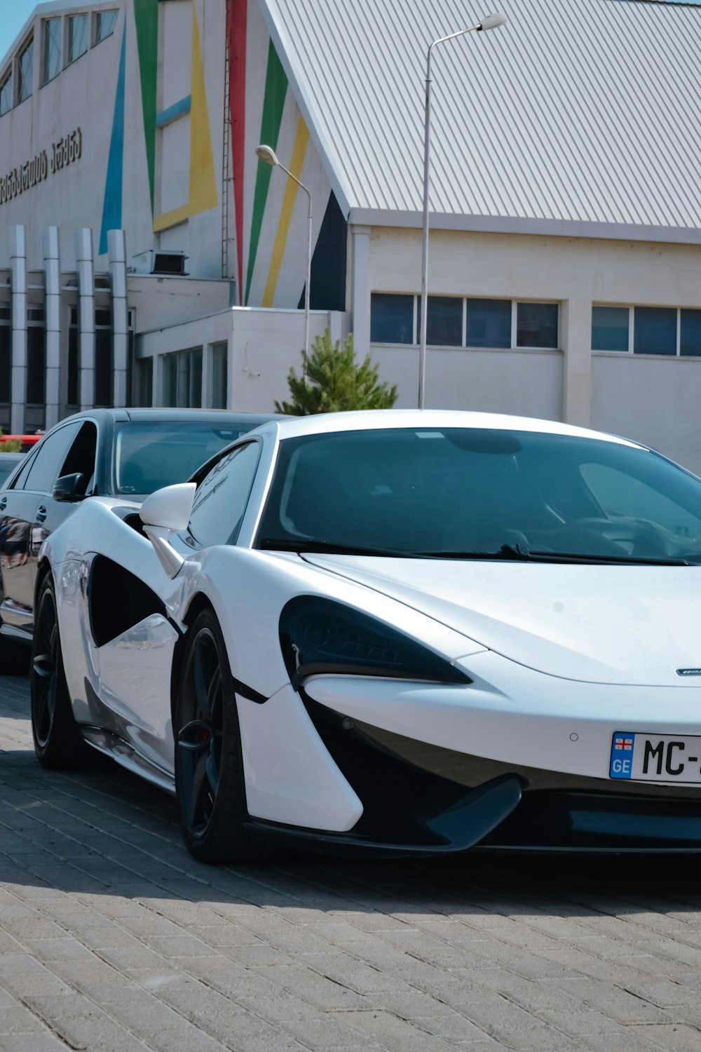 a white sports car parked in front of a building