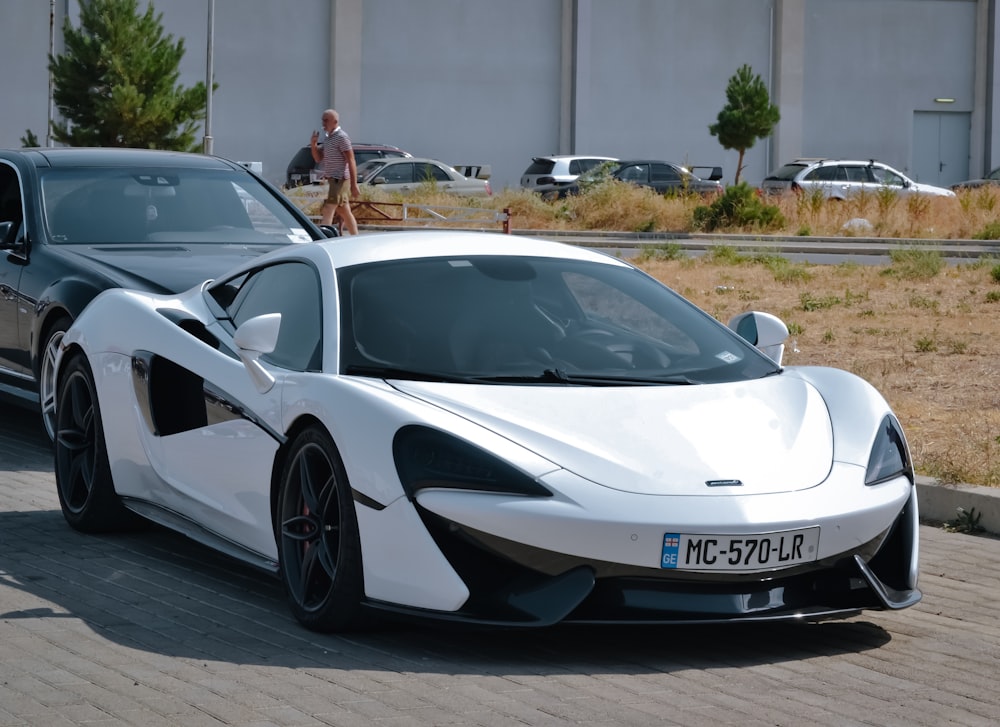 a white sports car parked in a parking lot