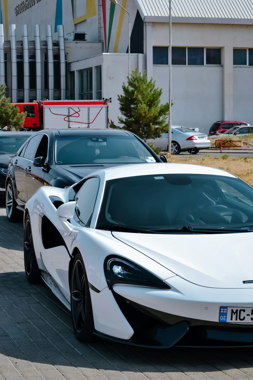 a white sports car parked in a parking lot