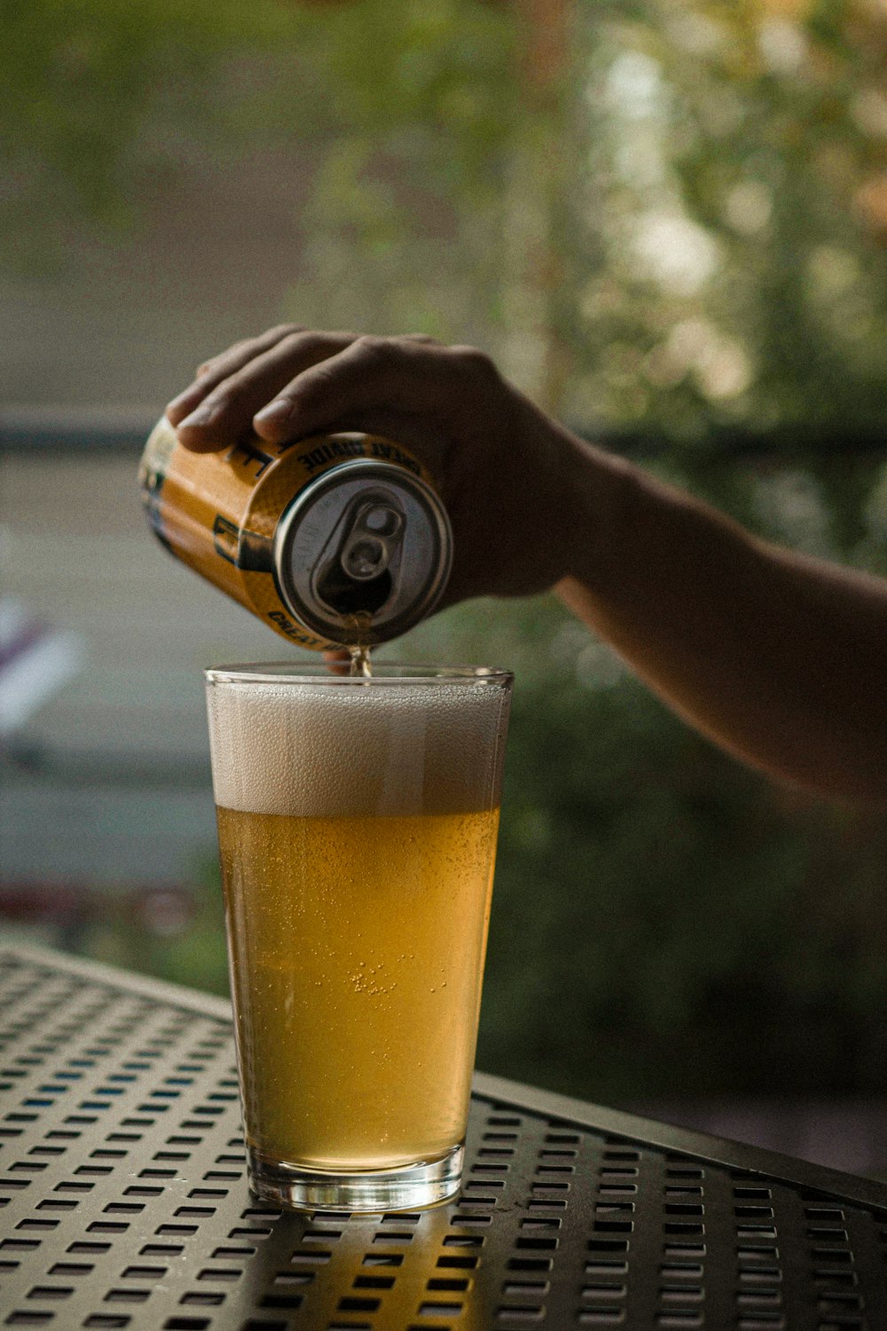 a hand pouring a drink into a glass