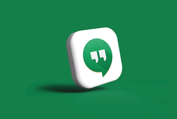 A 3D icon featuring a green speech bubble with white quotation marks inside is set against a solid green background. The speech bubble is slightly tilted and appears to be casting a subtle shadow.