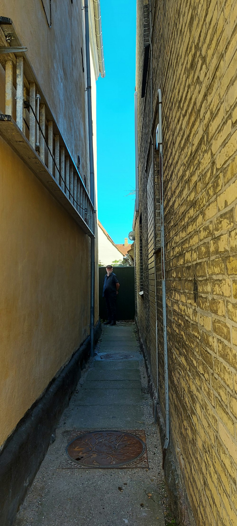 a person standing in a narrow alley between two buildings