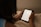 A person is holding an e-reader device, reading text from it. The background is soft and out of focus, giving a cozy and calm ambiance.