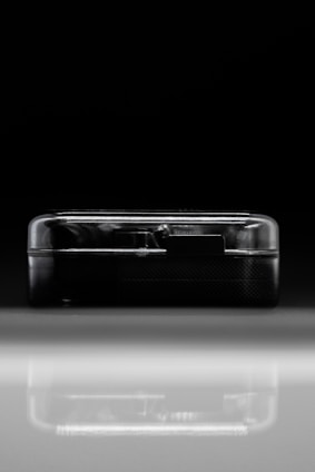 Close-up of a sleek, modern GPS tracking device with metallic blue and black gradient finish on a dark background.