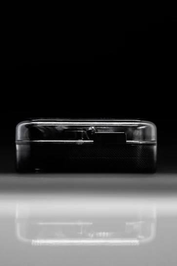 Sleek futuristic electronic gadget displayed on a dark minimalist background with subtle cyberpunk lighting.