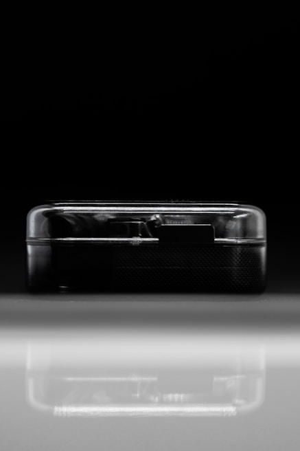 Macro shot of a sleek hardware device with glass-like surfaces reflecting ambient light