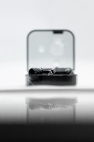 Close-up of a sleek, animated gadget glowing softly on a wooden shelf.