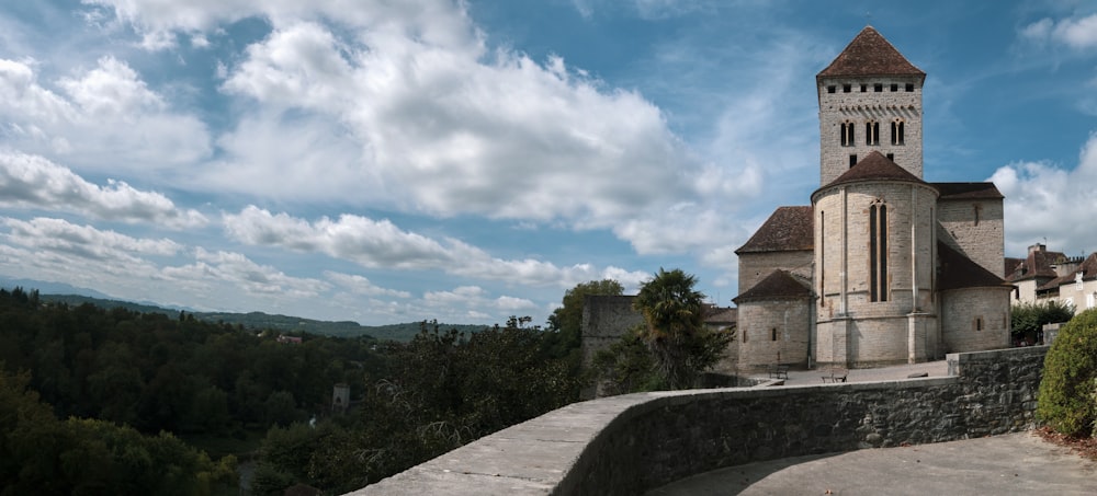 a stone wall with a tower and trees in the background