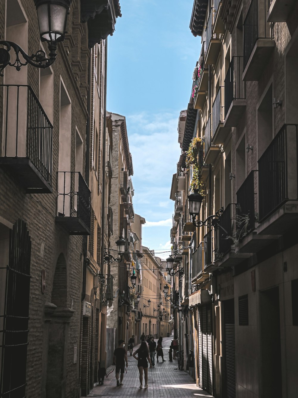 people walking down a narrow street