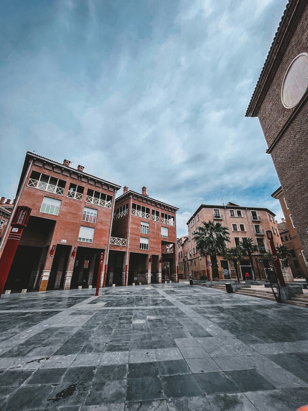 a brick courtyard with buildings in the background