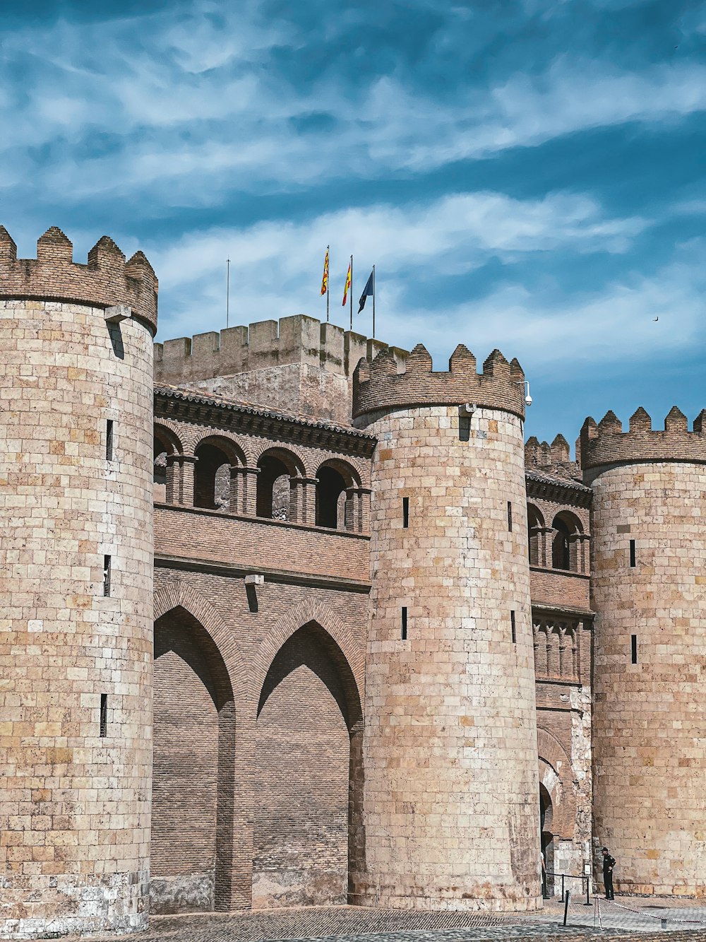 a stone castle with flags on top