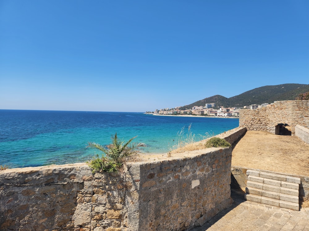 a stone wall overlooking a body of water