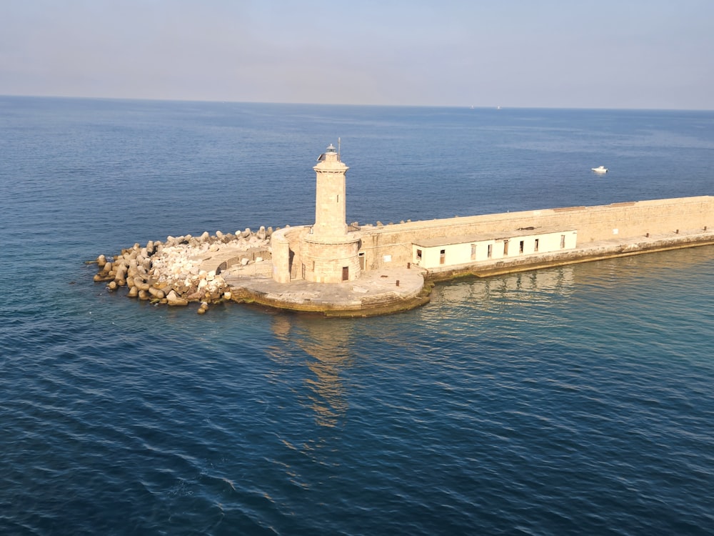 a lighthouse on a rock in the middle of the ocean