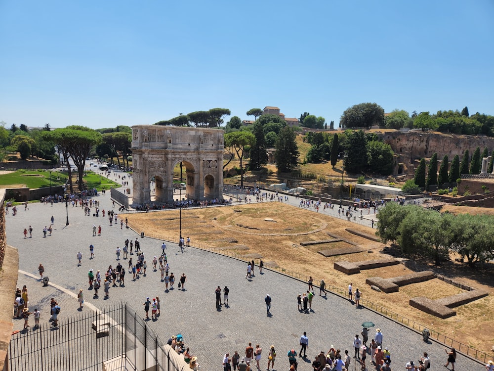 a large group of people walking around a large stone structure