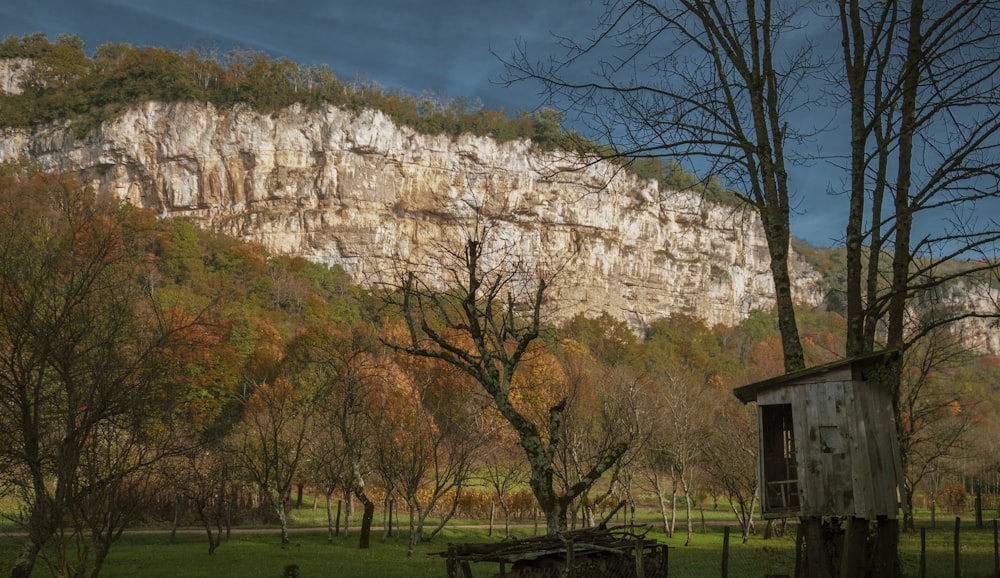 a small building in front of a mountain