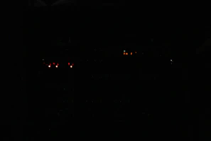 Close-up of industrial communication repeater equipment with glowing indicator lights in a dim control room