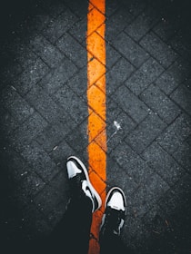 a pair of feet with orange and black striped socks
