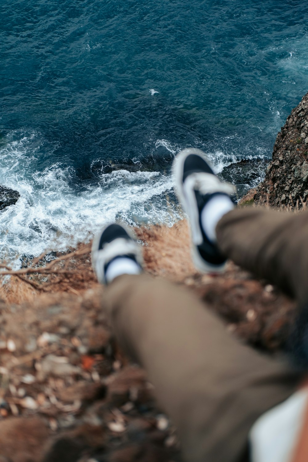 a person's feet on a rock by a body of water