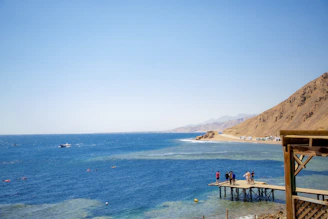 a group of people walking on a dock over a body of water