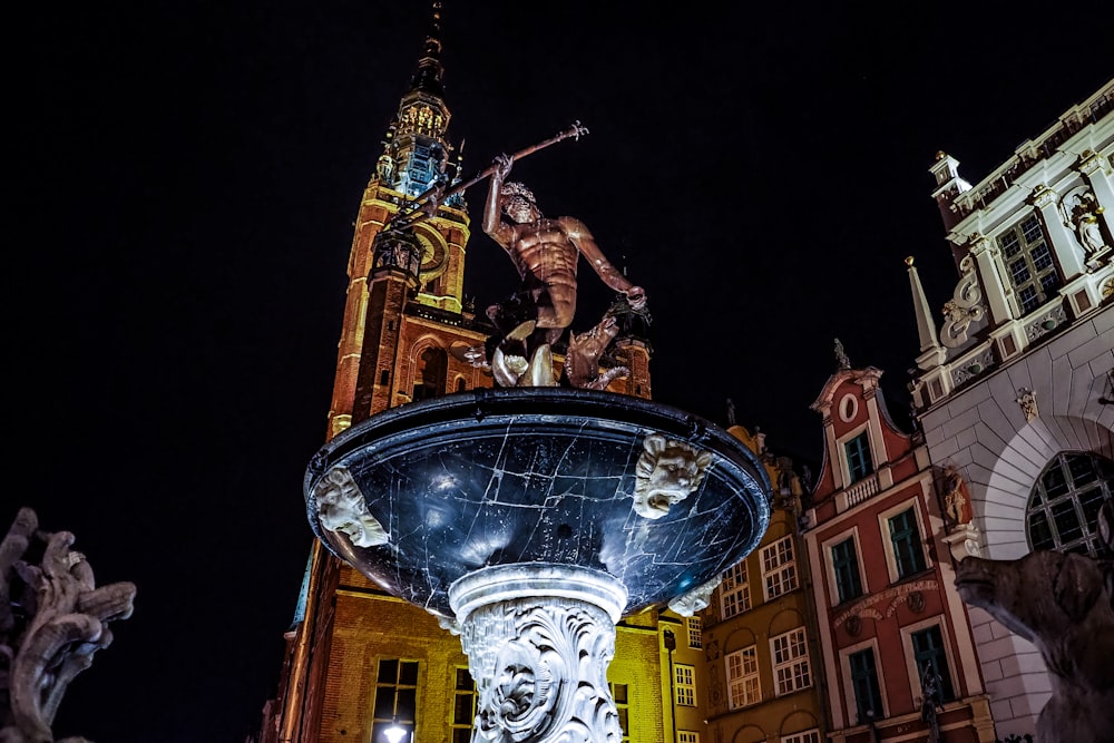 a statue of a person on a globe in front of a building